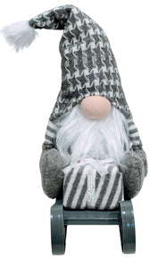 Gray Gnome Sitting on Gray Sled Holding a Christmas Gift