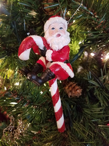 Santa sitting on candy cane ornament resin 6"
